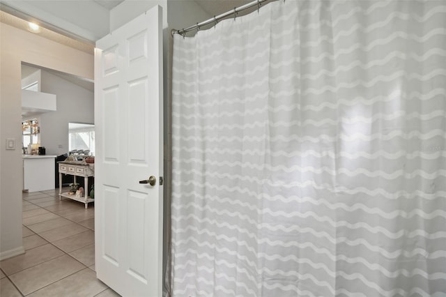 bathroom with tile patterned floors, lofted ceiling, and a shower with curtain