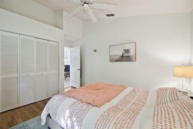 bedroom featuring wood-type flooring, a textured ceiling, a closet, ceiling fan, and lofted ceiling