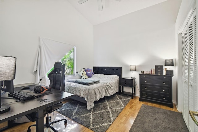 bedroom with high vaulted ceiling, hardwood / wood-style flooring, a closet, and ceiling fan