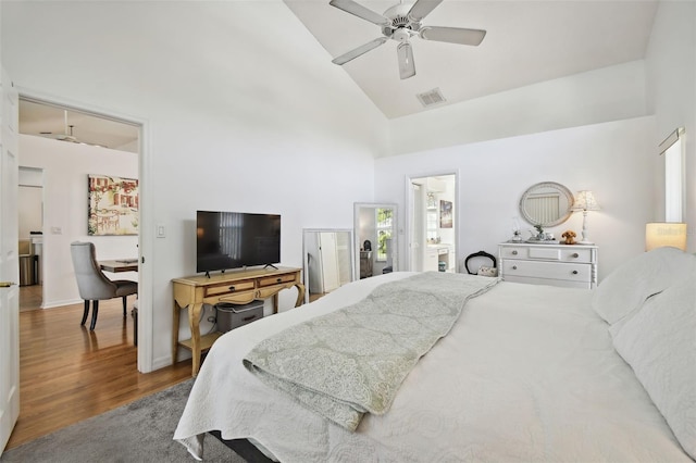 bedroom featuring hardwood / wood-style flooring, ceiling fan, high vaulted ceiling, and connected bathroom