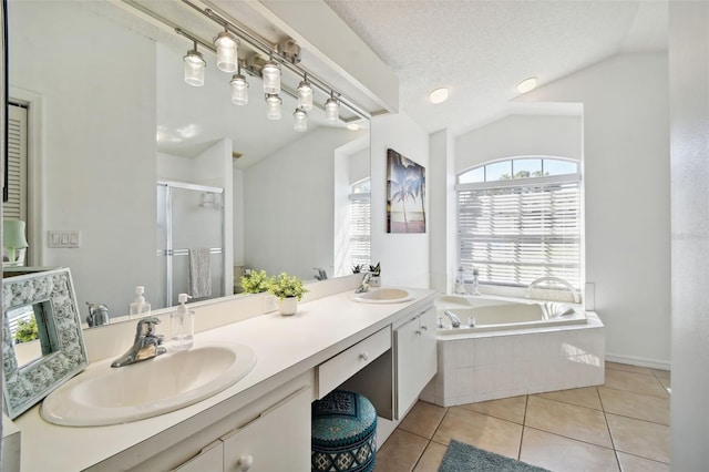 bathroom with vanity, independent shower and bath, vaulted ceiling, and tile patterned floors