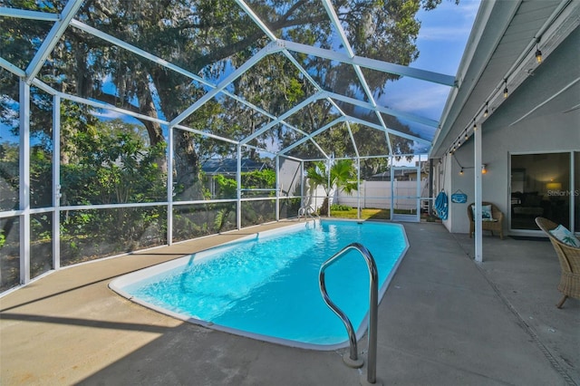 view of swimming pool with a patio, a shed, and glass enclosure