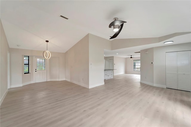 unfurnished living room with light wood-type flooring, vaulted ceiling, and ceiling fan