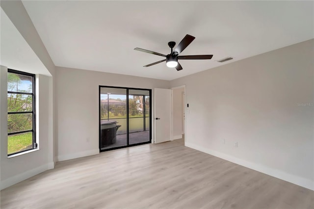 spare room with ceiling fan, plenty of natural light, and light wood-type flooring