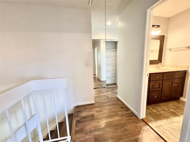 corridor with wood-type flooring and sink