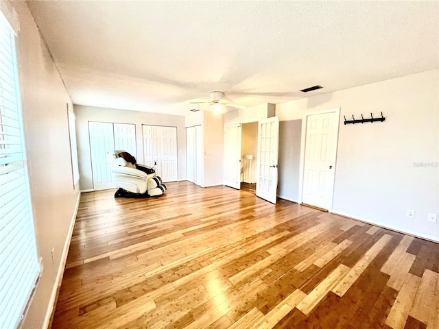 spare room with hardwood / wood-style floors, a textured ceiling, and ceiling fan