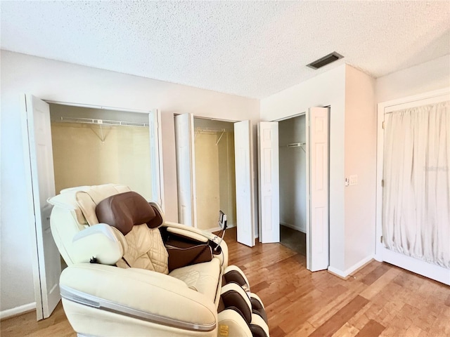 sitting room with light hardwood / wood-style flooring and a textured ceiling