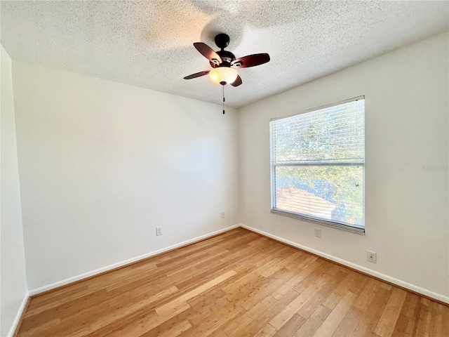 unfurnished room featuring a textured ceiling, light wood-type flooring, and ceiling fan