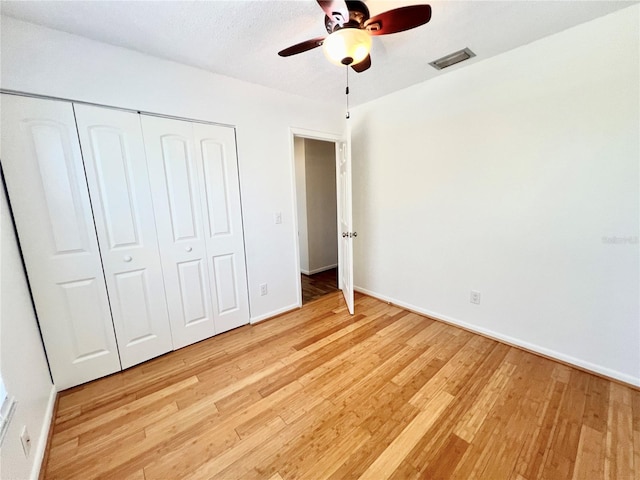 unfurnished bedroom featuring a closet, light wood-type flooring, and ceiling fan