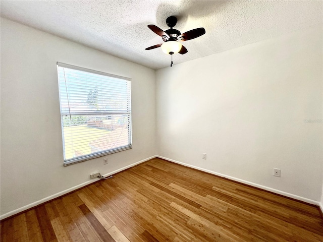 empty room with a textured ceiling, hardwood / wood-style flooring, and ceiling fan