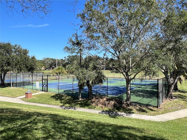 view of tennis court featuring a lawn