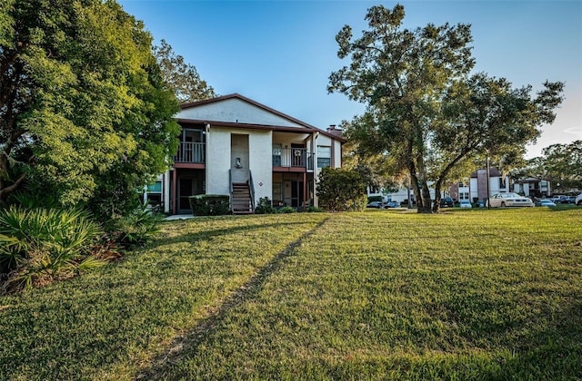 view of front of home featuring a front yard and a balcony