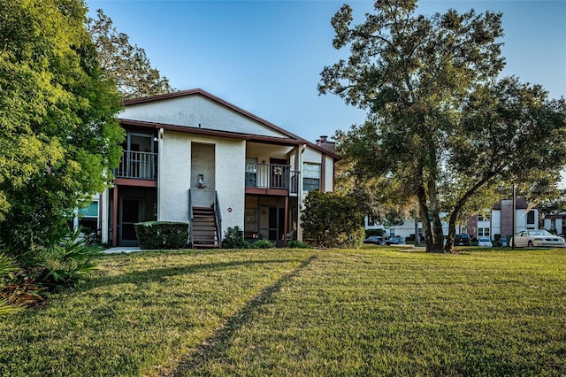 3455 Countryside Blvd Unit 52, Clearwater, FL 33761 - view of front of property with a chimney, stucco siding, a front lawn, and stairs
