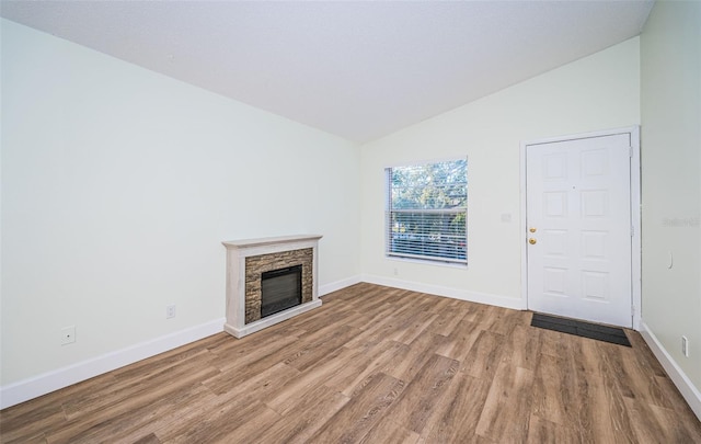 3455 Countryside Blvd Unit 52, Clearwater, FL 33761 - unfurnished living room with a fireplace, wood finished floors, vaulted ceiling, and baseboards