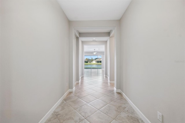 hallway featuring a water view and light tile patterned floors