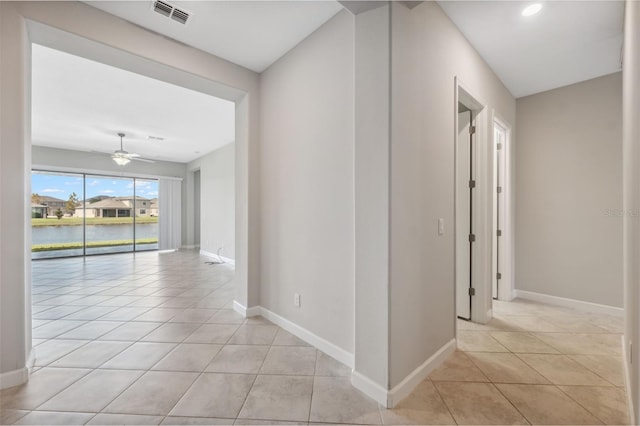 hallway featuring a water view and light tile patterned floors