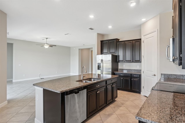 kitchen with sink, a kitchen island with sink, stainless steel appliances, and light tile patterned flooring