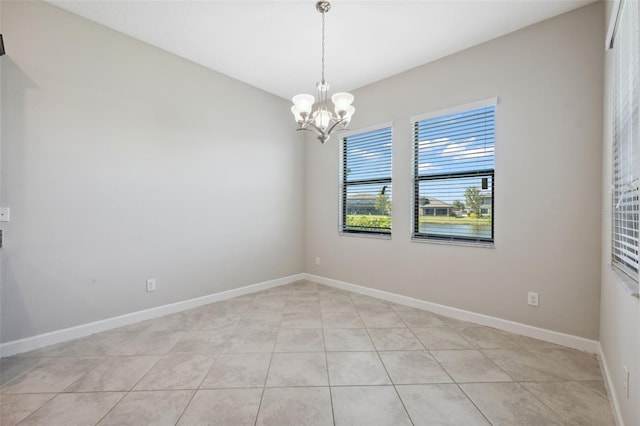 tiled empty room featuring a notable chandelier