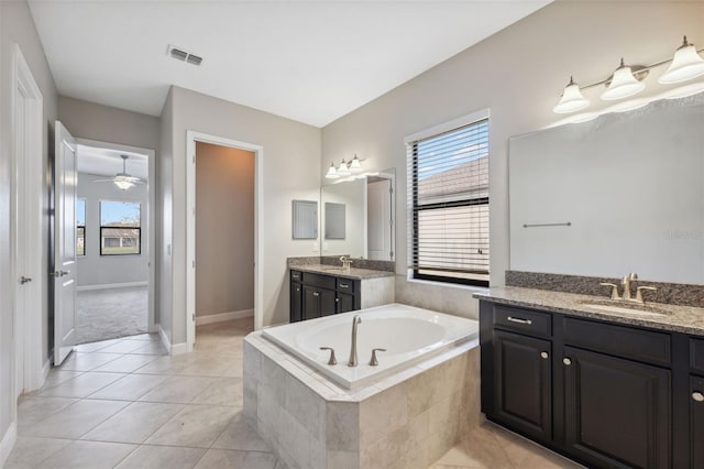 bathroom featuring vanity, ceiling fan, tiled tub, and tile patterned flooring