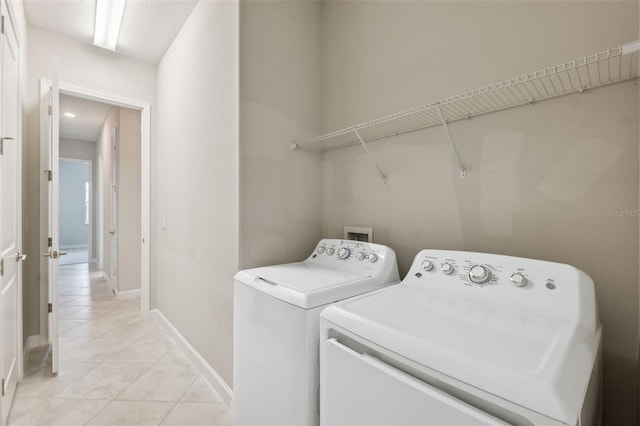 laundry room featuring washing machine and dryer and light tile patterned flooring