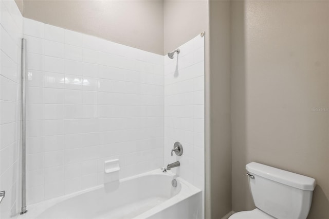 bathroom with toilet and tiled shower / bath