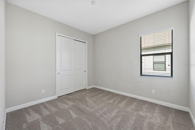 unfurnished bedroom featuring carpet floors and a closet