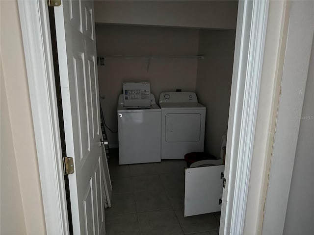 laundry area with washer and clothes dryer and dark tile patterned flooring