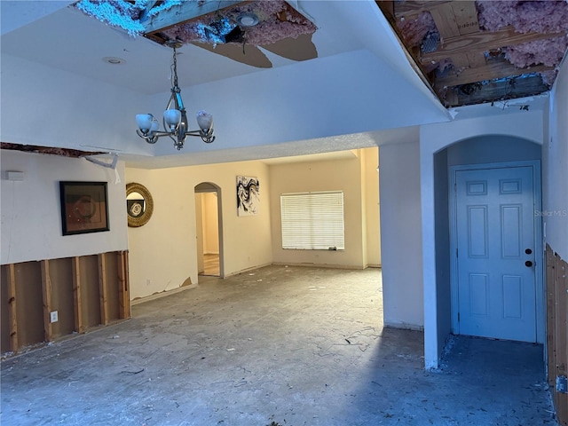 unfurnished living room with ceiling fan with notable chandelier