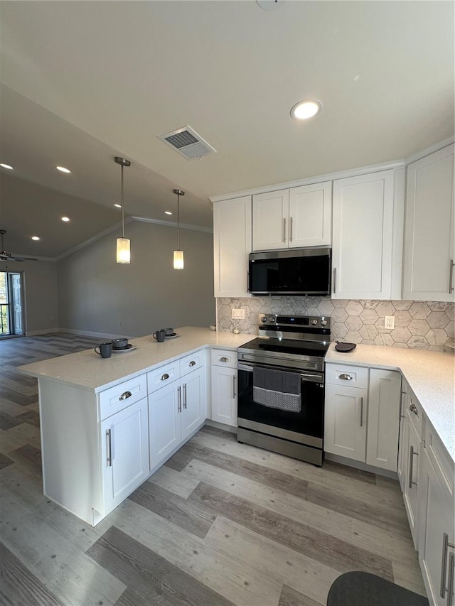 kitchen with kitchen peninsula, white cabinets, pendant lighting, light wood-type flooring, and appliances with stainless steel finishes