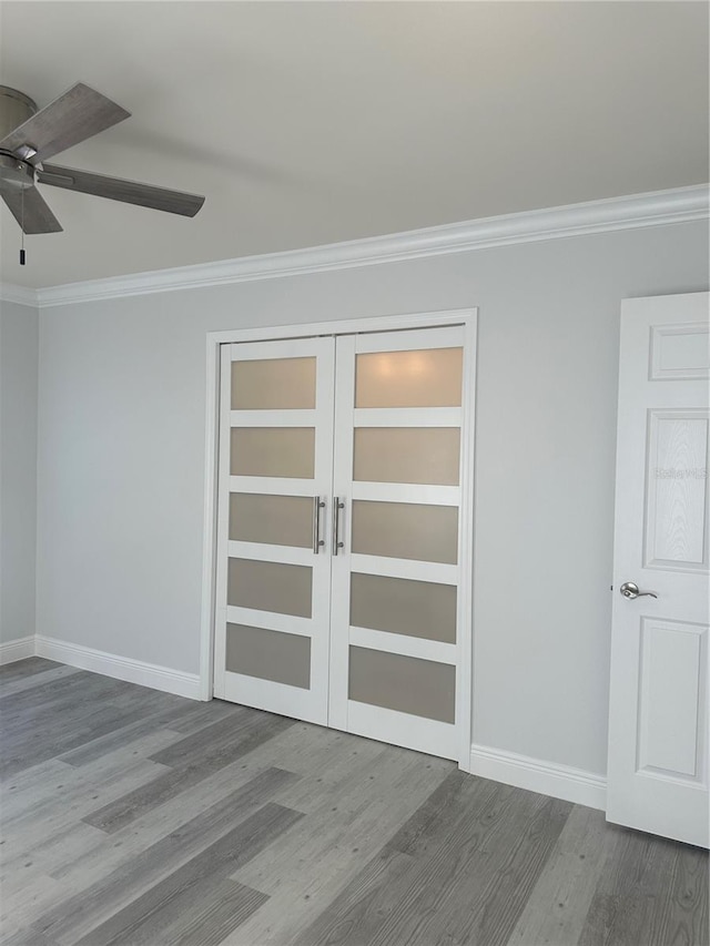 empty room with french doors, ornamental molding, and wood-type flooring