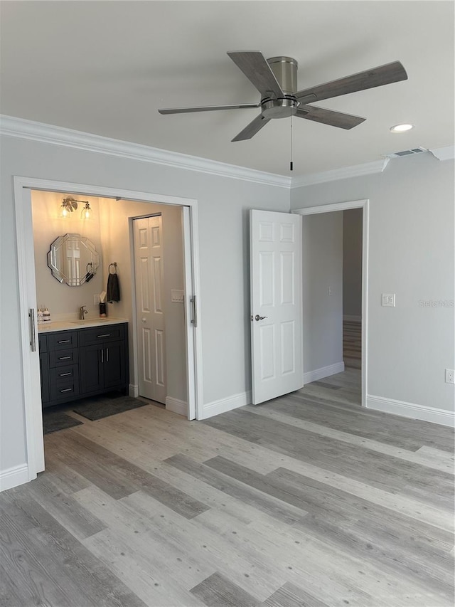 interior space featuring ornamental molding, sink, light wood-type flooring, and ceiling fan