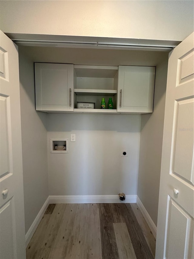 laundry area featuring electric dryer hookup, washer hookup, cabinets, and dark hardwood / wood-style flooring