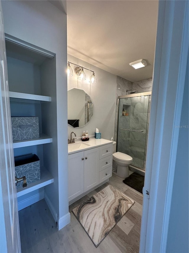 bathroom with vanity, an enclosed shower, hardwood / wood-style floors, and toilet