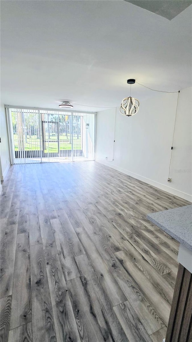 unfurnished living room featuring expansive windows and hardwood / wood-style floors