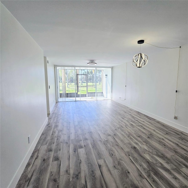 unfurnished living room with a wall of windows and dark hardwood / wood-style flooring