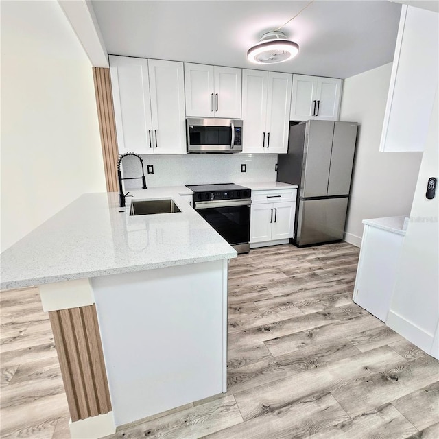 kitchen with appliances with stainless steel finishes, white cabinetry, and sink