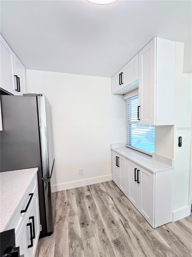 kitchen featuring white cabinetry, light wood-type flooring, and stainless steel refrigerator