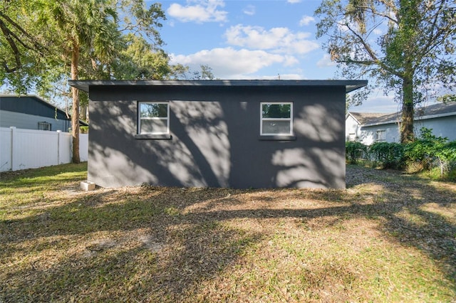 back of house featuring a yard and an outdoor structure