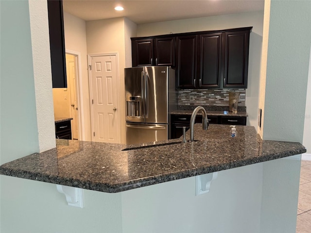 kitchen with stainless steel fridge, kitchen peninsula, and a breakfast bar