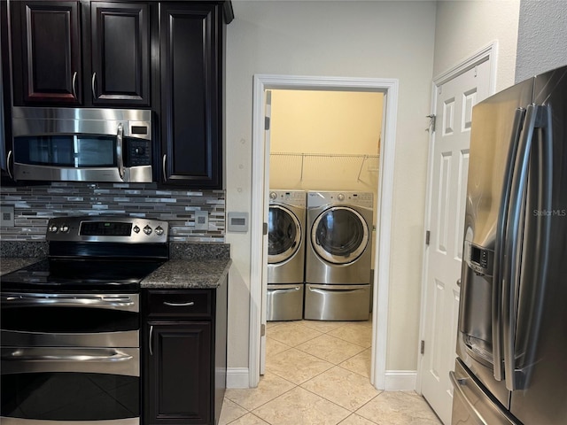 kitchen with appliances with stainless steel finishes, light tile patterned floors, washing machine and clothes dryer, and backsplash