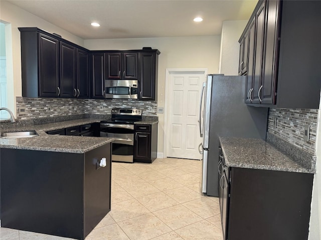 kitchen featuring sink, backsplash, light tile patterned flooring, and appliances with stainless steel finishes