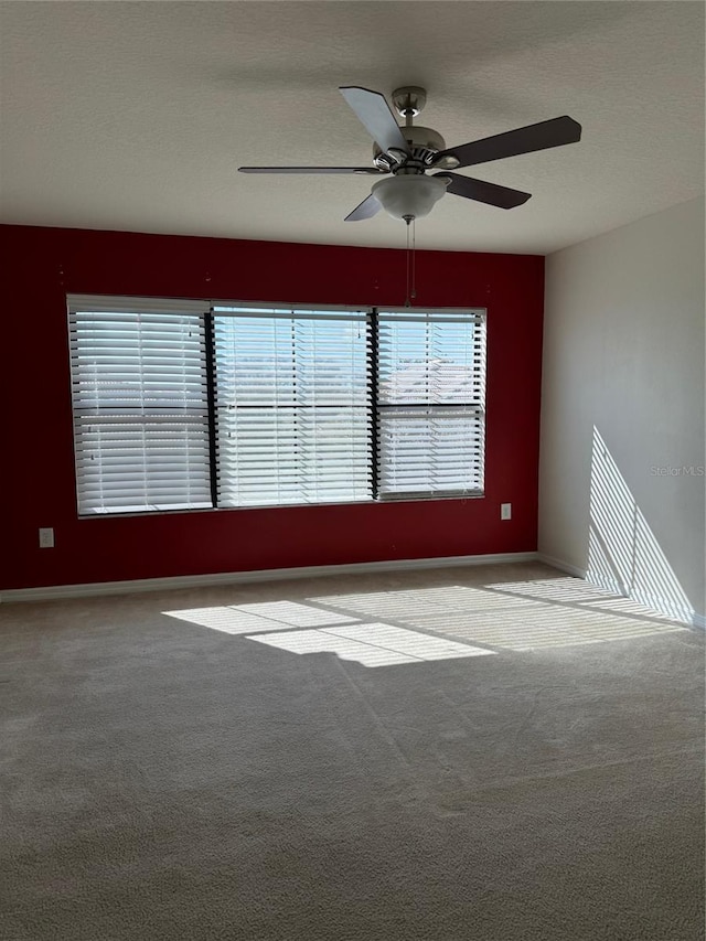 carpeted empty room featuring a textured ceiling and ceiling fan