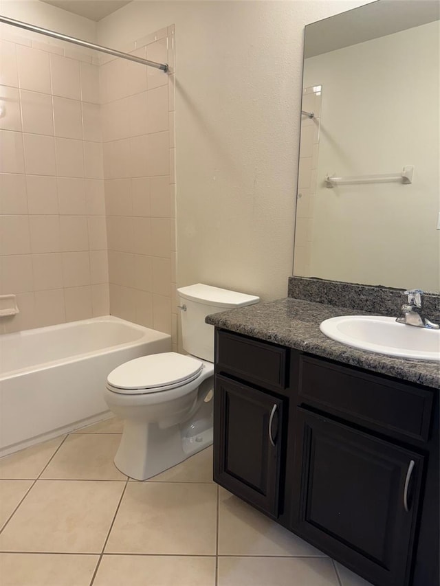 full bathroom with vanity, tiled shower / bath combo, tile patterned floors, and toilet