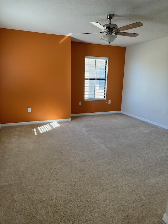 carpeted empty room featuring ceiling fan and a textured ceiling