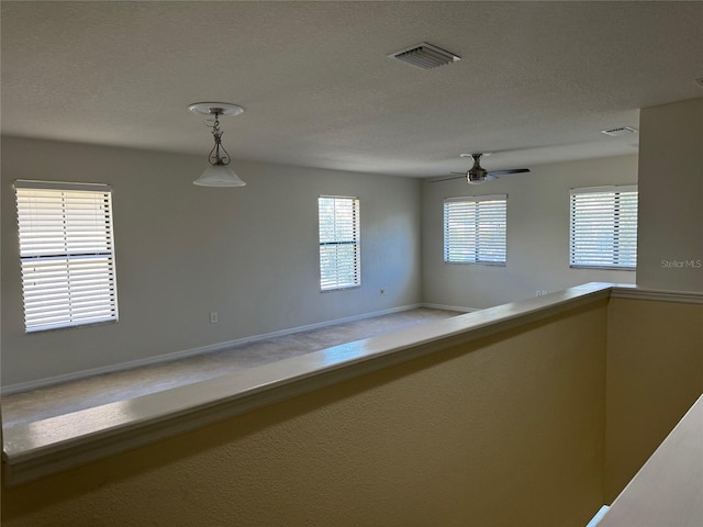 empty room featuring ceiling fan and a textured ceiling