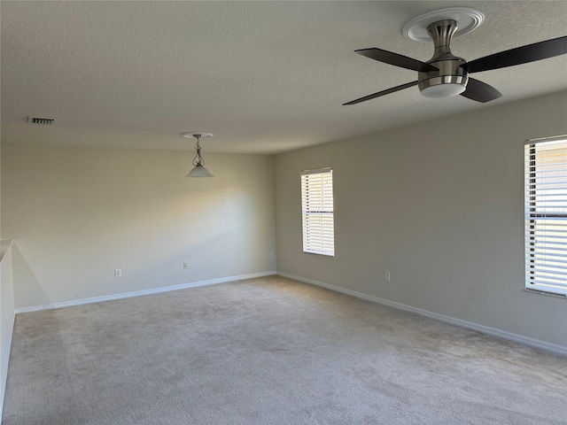 carpeted empty room with a textured ceiling and ceiling fan