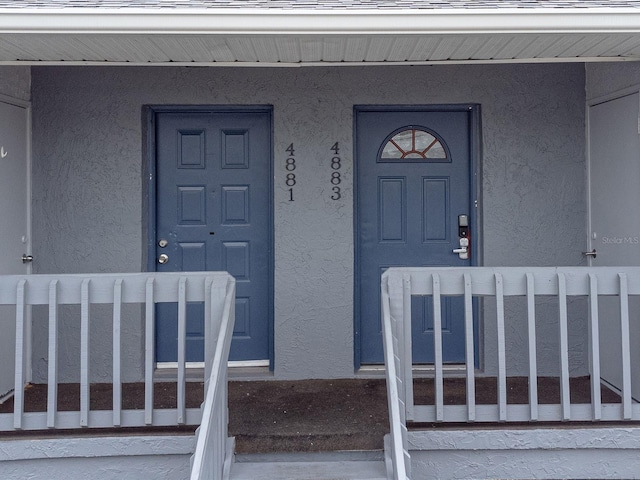 view of exterior entry featuring covered porch