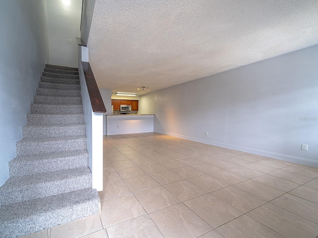 staircase featuring a textured ceiling and tile patterned flooring