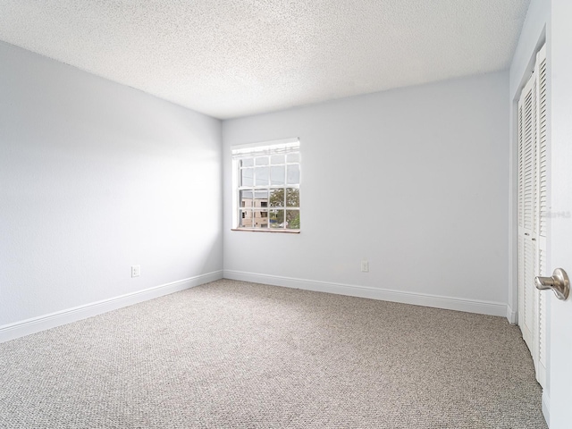 unfurnished bedroom featuring a textured ceiling, carpet floors, and a closet