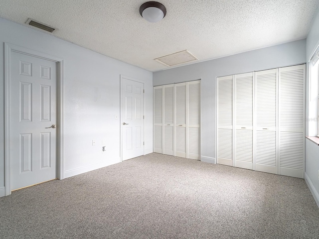 unfurnished bedroom with carpet flooring and multiple closets